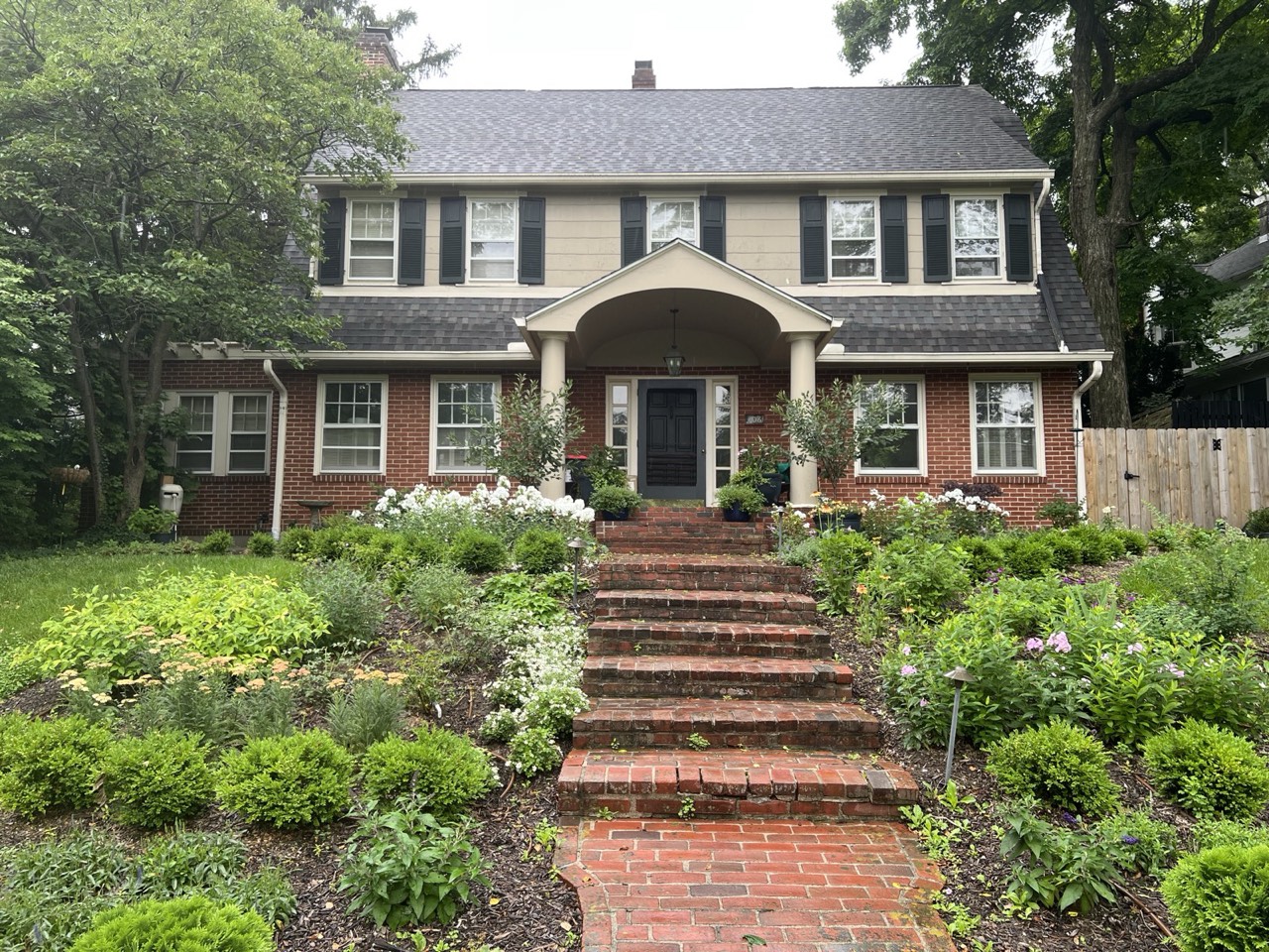 The finished front beds flanking the brick steps, seen from the street on a misty morning