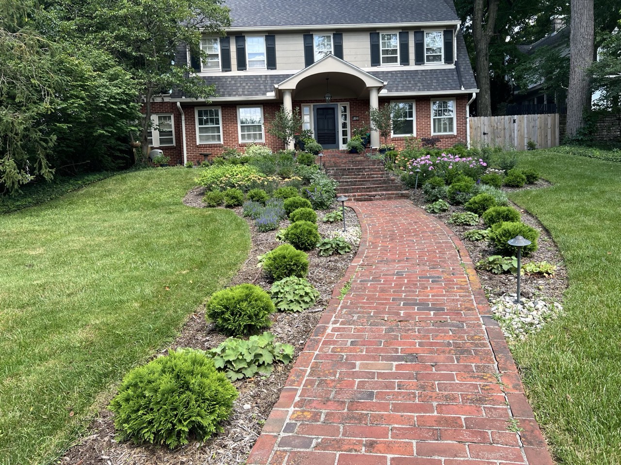 Boxwood-lined brick walkway and manicured front beds