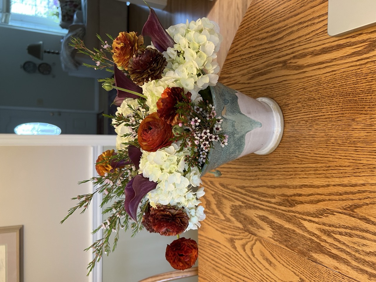 Autumn arrangement of ranunculus, hydrangea, and calla in a vase