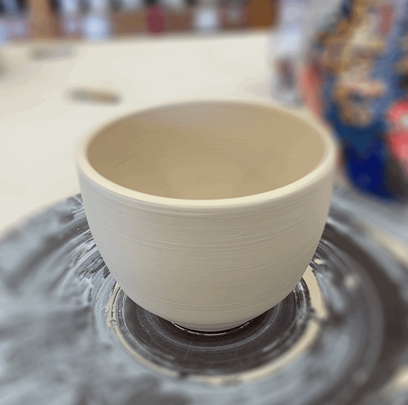 Freshly thrown ceramic cup on the wheel